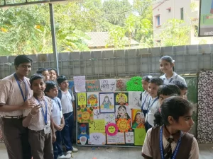 Students standing in front of decorative board